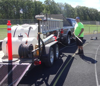 Kevin Palladino standing next to his truck with power washing equipment on a trailer at your service in Cheshire